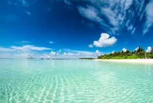 Stunning tropical beach scene in the Maldives with clear waters and blue sky, perfect for a paradise getaway.